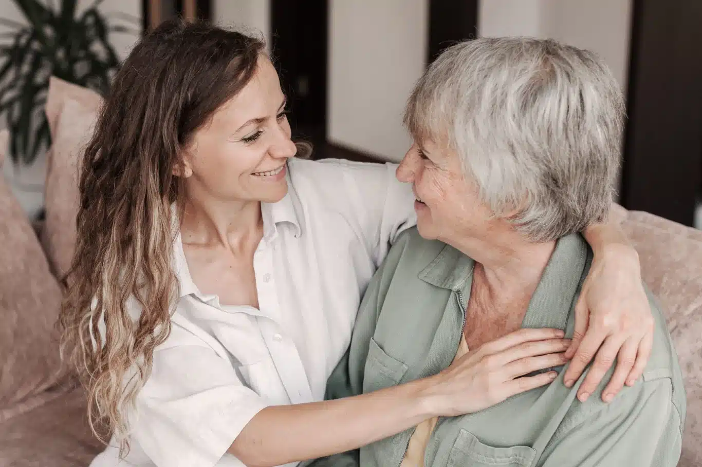 Liebevolle 24-Stunden Betreuung – Pflegerin umarmt Seniorin