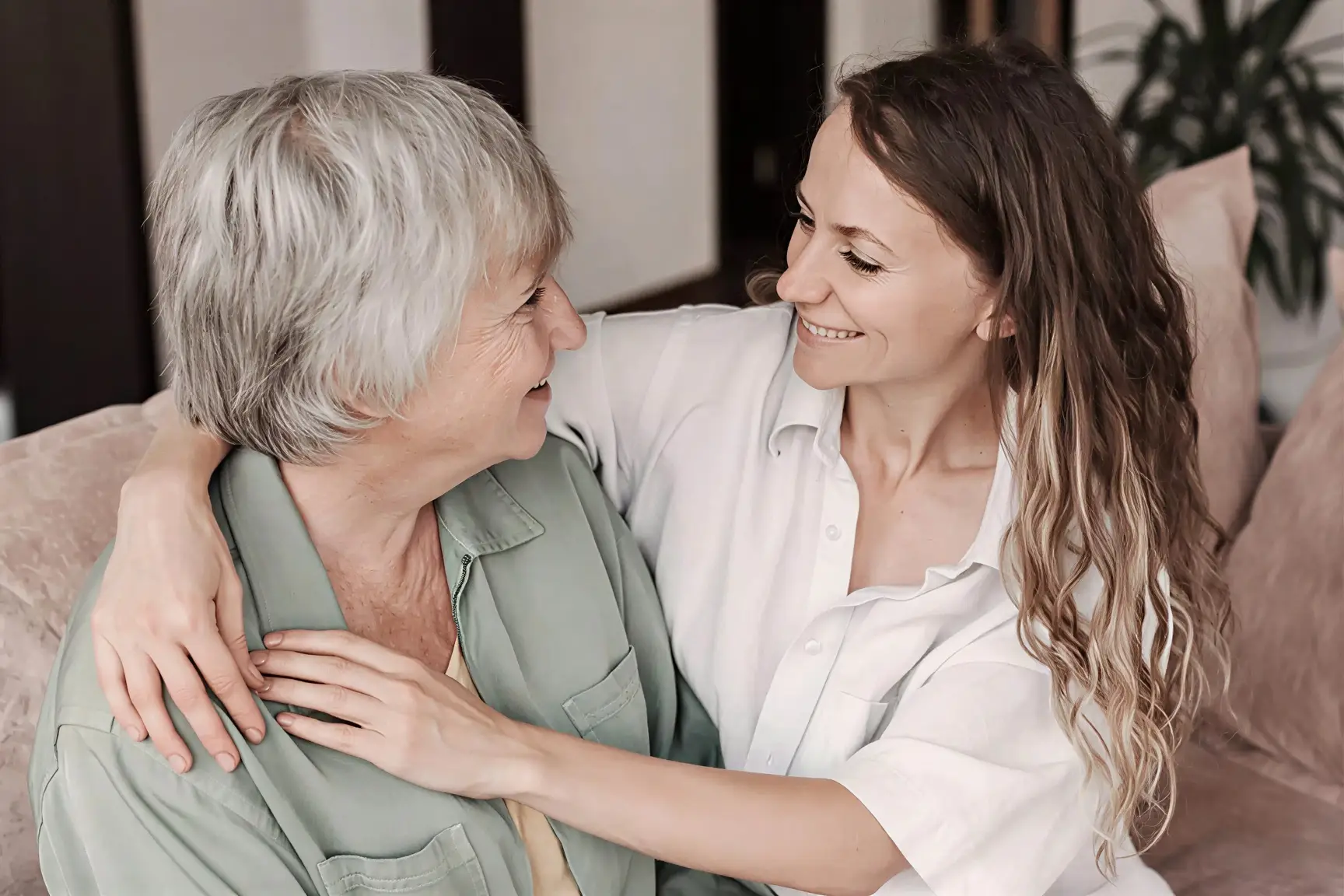 Liebevolle 24-Stunden Betreuung – Pflegerin umarmt Seniorin